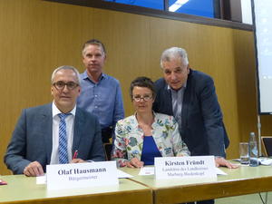 B&uuml;rgermeister Olaf Hausmann und Landr&auml;tin Kirsten Fr&uuml;ndt bei der Unterzeichnung der Absichtserkl&auml;rung zur Umsetzung eines Multifunktionalen Hauses im Stadtteil Betziesdorf. Im Hintergrund: Ortsvorsteher Dieter Tourte und Stadtverordnetenvorsteher Klaus Weber